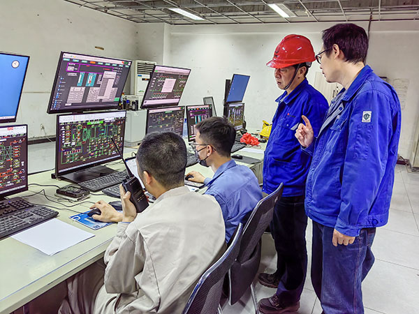 5月13日，動力車間三期鍋爐控制室，DCS改造工藝、儀表、電氣等部門聯(lián)合調試，車間主任姜軍虎與技術員畢加佳查看調試過程.jpg